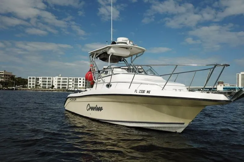 Slide: The Image of 2005 Century 2600 Walk-Around boat on water, clear sky, urban background. - 7