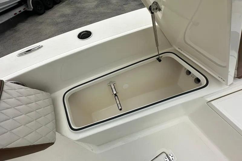 Slide: The Image of Open storage compartment on 2026 Pioneer 220 Bay Sport boat, featuring cushioned seating. - 10