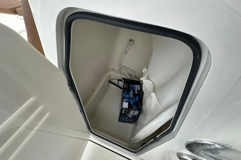 Slide: The Image of Open storage compartment in 2026 Pioneer 220 Bay Sport boat with battery inside. - 12
