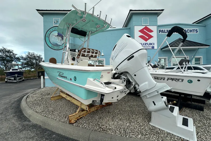 Slide: The Image of 2026 Pioneer 220 Bay Sport boat displayed at a marine dealership. - 2