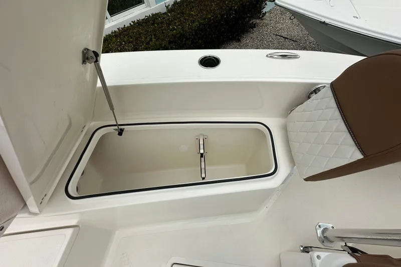 Slide: The Image of Open storage compartment on 2026 Pioneer 220 Bay Sport boat with cushioned seating. - 8