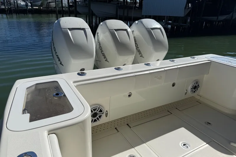 Slide: The Image of 2016 SeaVee 370Z boat with triple Mercury engines docked by the water. - 12
