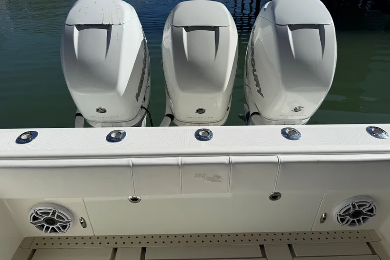 Slide: The Image of 2016 SeaVee 370Z boat with triple Mercury outboard engines, docked on calm water. - 13