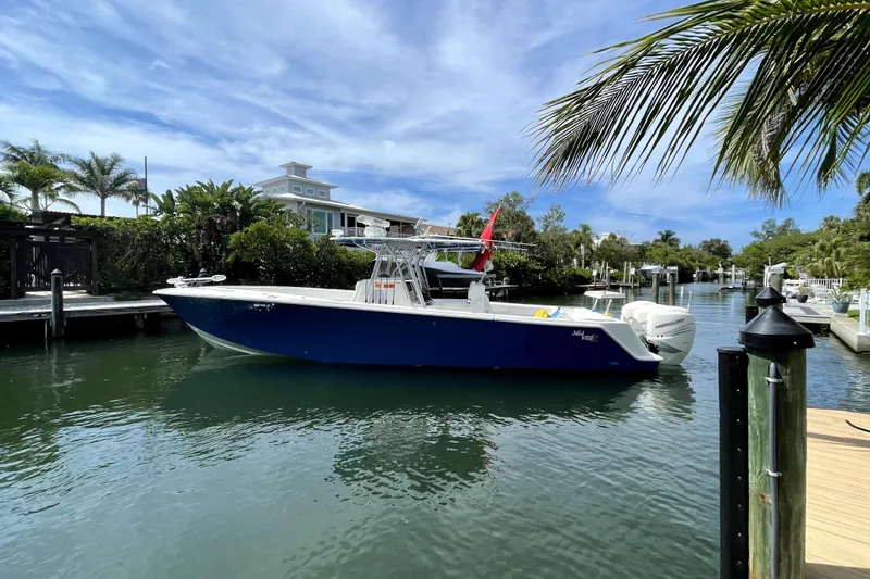 Slide: The Image of 2016 SeaVee 370Z boat docked in a scenic, tropical canal setting. - 2