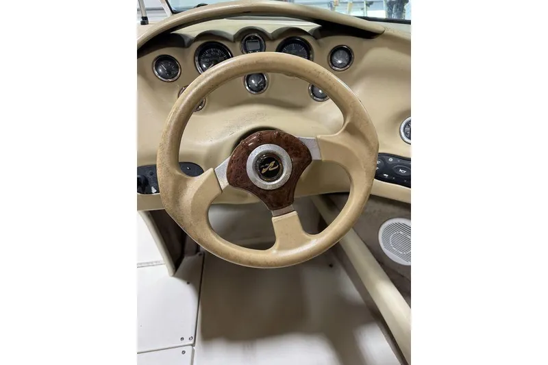 Slide: The Image of Steering wheel of a 2000 Sea Ray 210 Bow Rider boat, beige dashboard. - 11