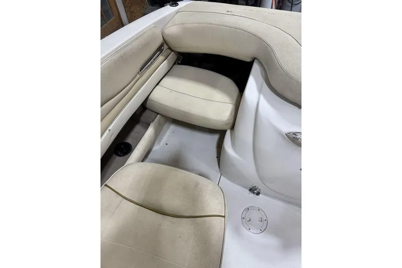 Slide: The Image of Interior seating of a 2000 Sea Ray 210 Bow Rider boat, featuring beige upholstery. - 16