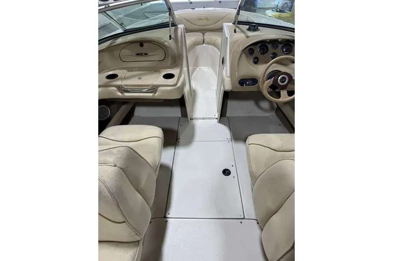 Slide: The Image of Interior of 2000 Sea Ray 210 Bow Rider boat with beige seating and dashboard. - 9
