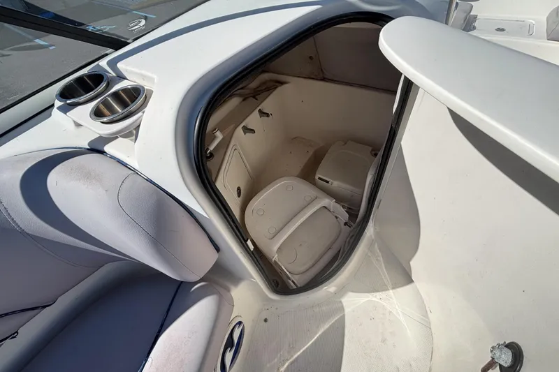Slide: The Image of 2006 Hurricane SunDeck 217 OB boat interior with storage compartment and cup holders. - 12