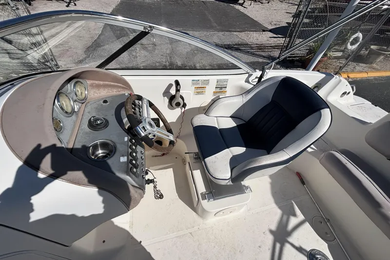 Slide: The Image of 2006 Hurricane SunDeck 217 OB boat cockpit with steering wheel and captain's chair. - 14