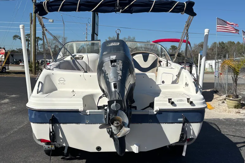 Slide: The Image of 2006 Hurricane SunDeck 217 OB boat with Yamaha outboard motor, parked outdoors. - 2