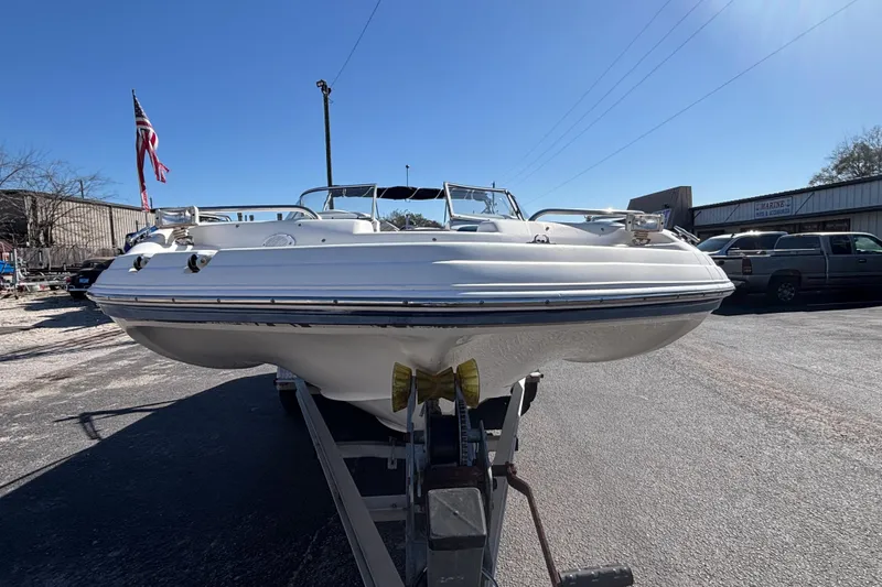 Slide: The Image of 2006 Hurricane SunDeck 217 OB boat on trailer, parked outdoors under clear blue sky. - 5