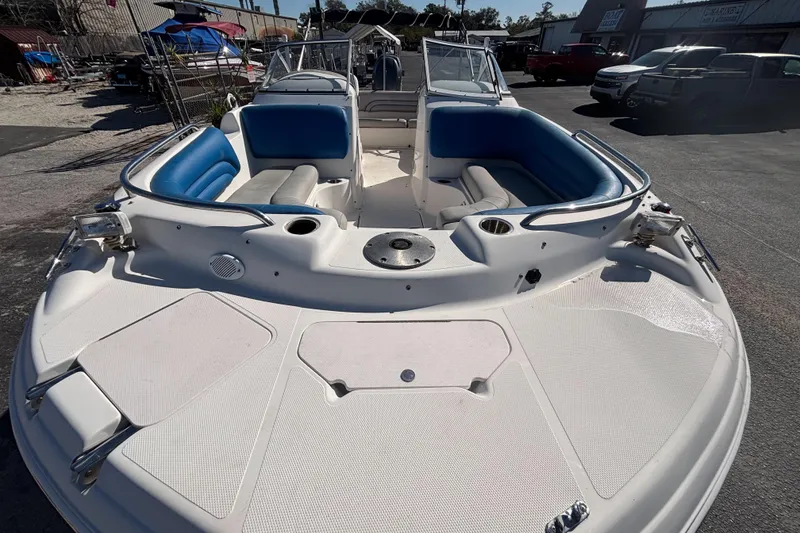 Slide: The Image of 2006 Hurricane SunDeck 217 OB boat with blue seating, docked outdoors. - 7