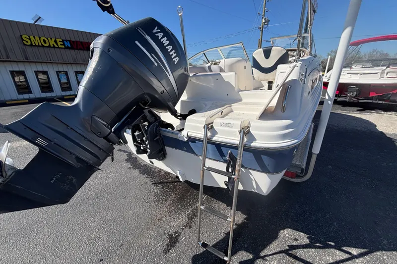 Slide: The Image of 2006 Hurricane SunDeck 217 OB with Yamaha outboard motor, parked near a store. - 9