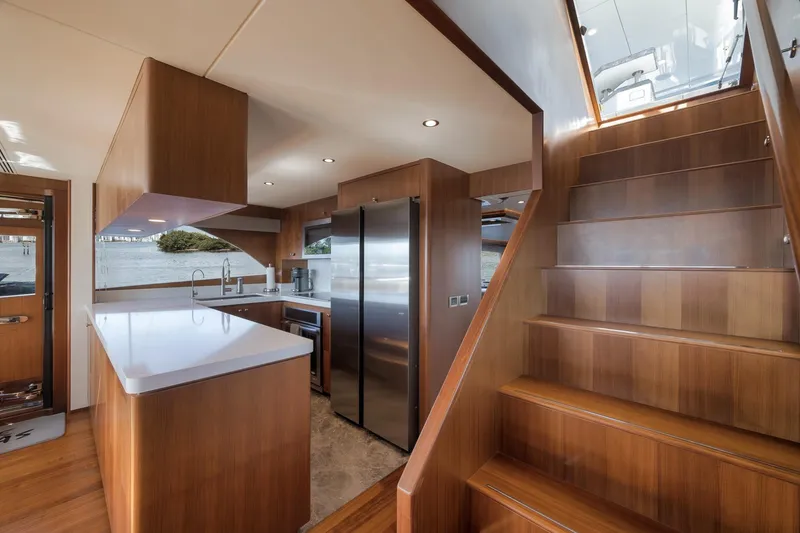 Slide: The Image of Luxurious kitchen and staircase on 2017 Ocean Alexander 85 E yacht, featuring modern wood finishes. - 14