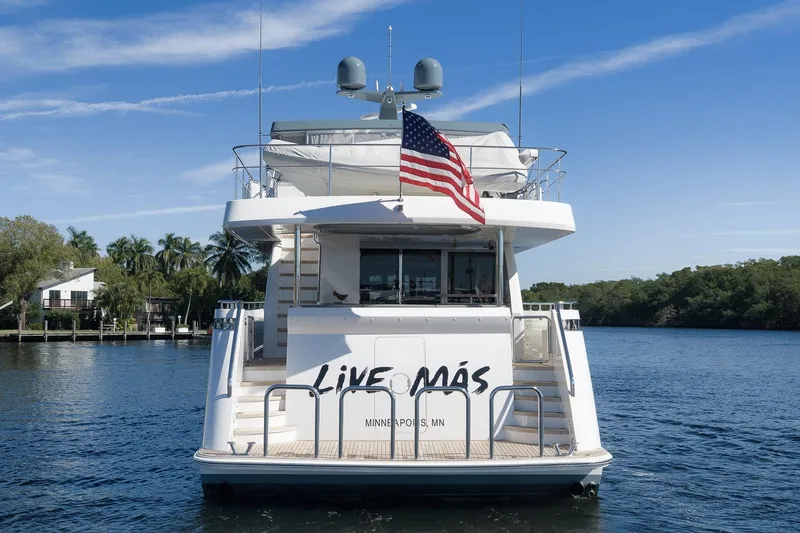 Slide: The Image of 2017 Ocean Alexander 85 E yacht with American flag, docked on a serene waterway. - 5