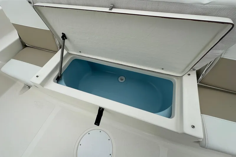 Slide: The Image of Open storage compartment on 2026 Bulls Bay 2200 XS boat, featuring blue interior. - 14