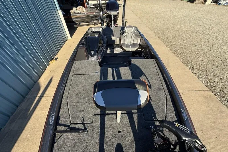 Slide: The Image of 2026 Skeeter ZXE20 fishing boat with spacious deck and seating, parked outdoors. - 24
