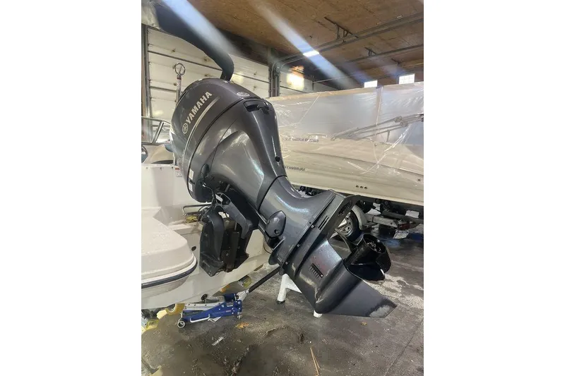 Slide: The Image of 2016 Stingray 191 DC boat with Yamaha outboard motor in a garage setting. - 10