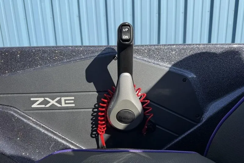 Slide: The Image of Control panel of 2026 Skeeter ZXE21 boat with throttle lever and red coiled cord. - 17