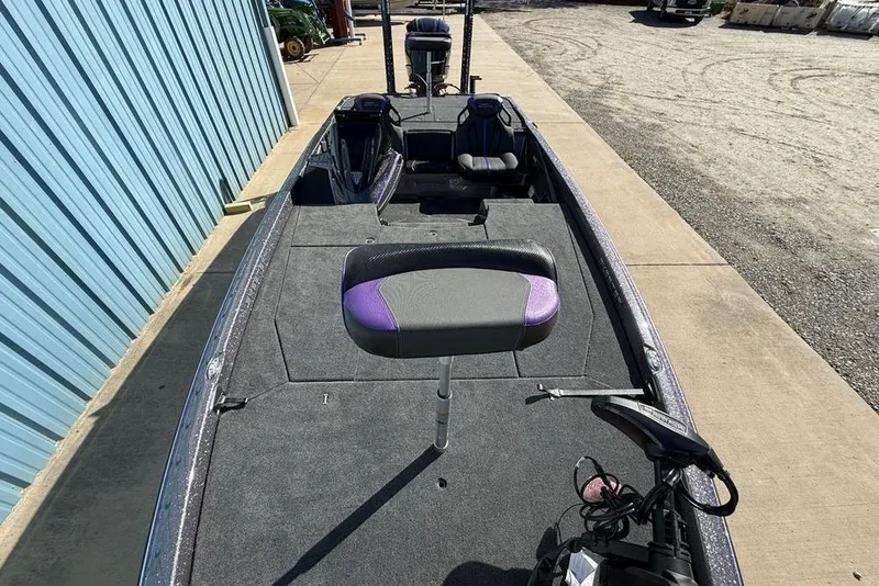 Slide: The Image of 2026 Skeeter ZXE21 fishing boat with purple accents, docked beside a blue building. - 23