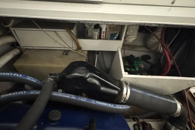 Slide: The Image of Engine compartment of a 1974 Bertram 31 Flybridge Cruiser with hoses and storage. - 11