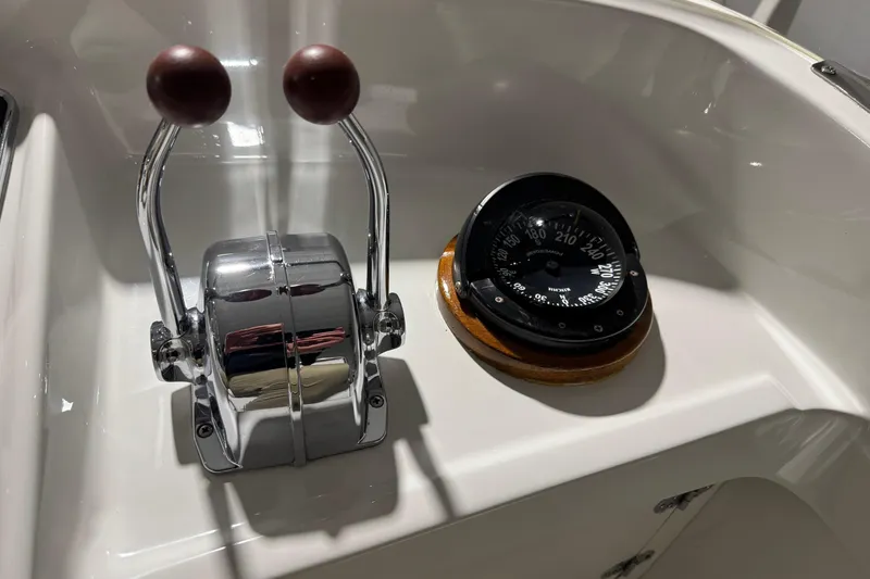 Slide: The Image of 1974 Bertram 31 Flybridge Cruiser controls and compass on white dashboard. - 16