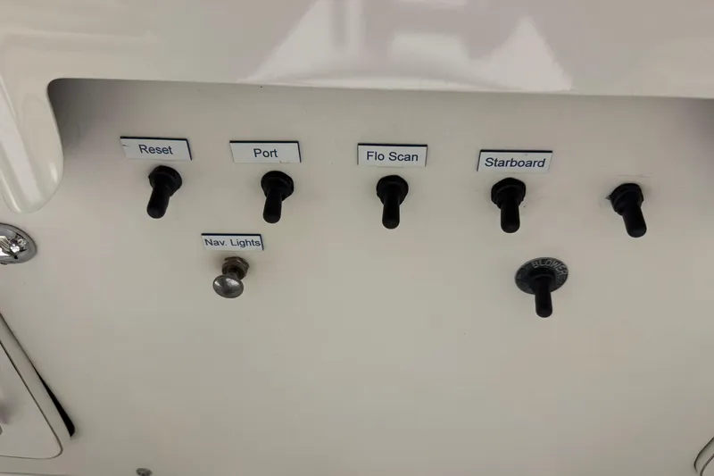 Slide: The Image of Control panel of a 1974 Bertram 31 Flybridge Cruiser with labeled switches. - 18