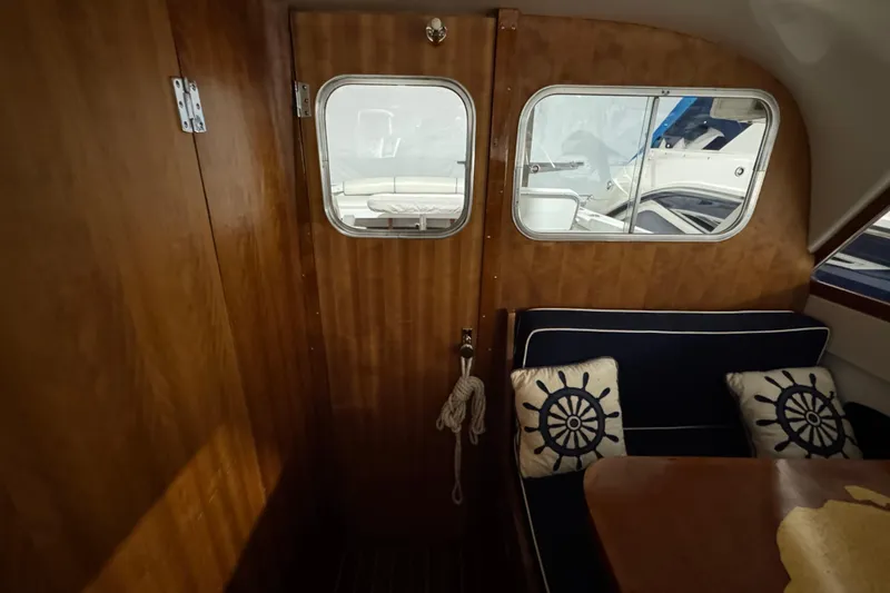 Slide: The Image of Interior of 1974 Bertram 31 Flybridge Cruiser with nautical-themed cushions and wooden paneling. - 21