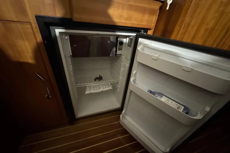 Slide: The Image of Open fridge inside 1974 Bertram 31 Flybridge Cruiser, wooden interior, minimal contents. - 28