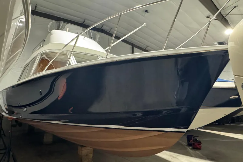 Slide: The Image of 1974 Bertram 31 Flybridge Cruiser in storage, showcasing sleek blue hull design. - 5