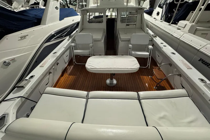 Slide: The Image of 1974 Bertram 31 Flybridge Cruiser interior with white seating and wooden deck. - 7