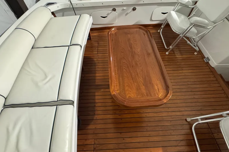 Slide: The Image of 1974 Bertram 31 Flybridge Cruiser interior with wooden table and white seating. - 8