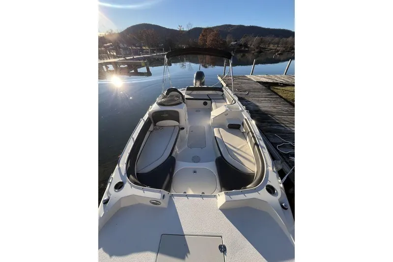 Slide: The Image of 2016 Stingray 192 SC boat docked on a sunny lake with scenic mountain views. - 6