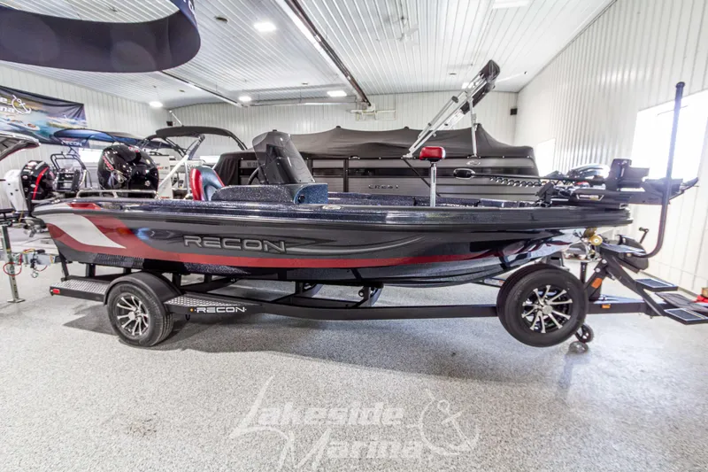 The Image of 2026 Recon 895 SC boat in showroom, featuring sleek design and modern trailer. - 1