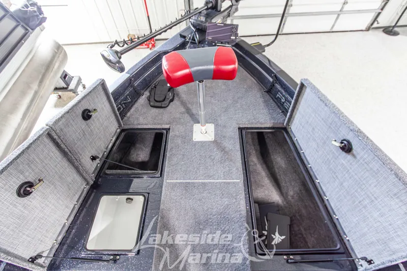 Slide: The Image of 2026 Recon 895 SC boat interior with storage compartments and red seat in a marina. - 27