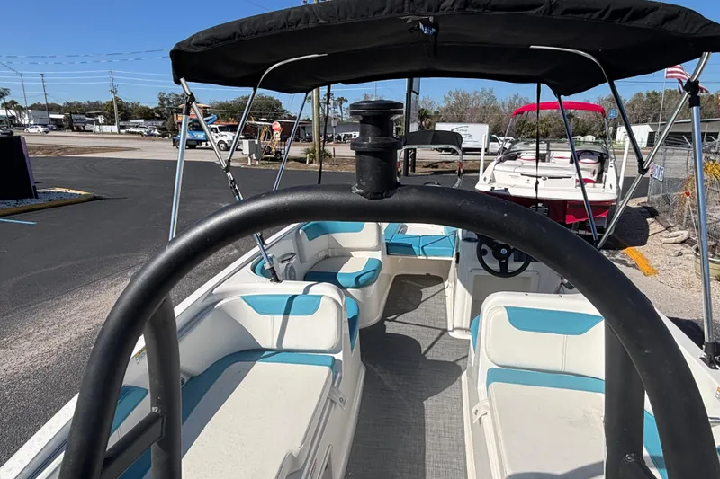 Slide: The Image of 2021 Bayliner Element E18 boat with blue and white seating, parked outdoors. - 23