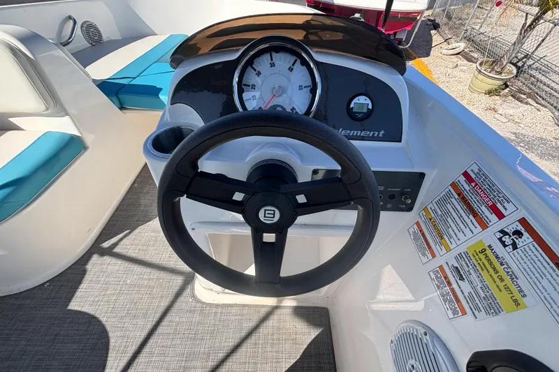Slide: The Image of 2021 Bayliner Element E18 boat dashboard with steering wheel and gauges. - 24