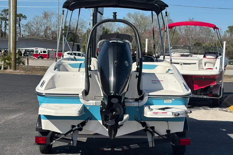 Slide: The Image of 2021 Bayliner Element E18 boat with outboard motor, parked on a trailer. - 3