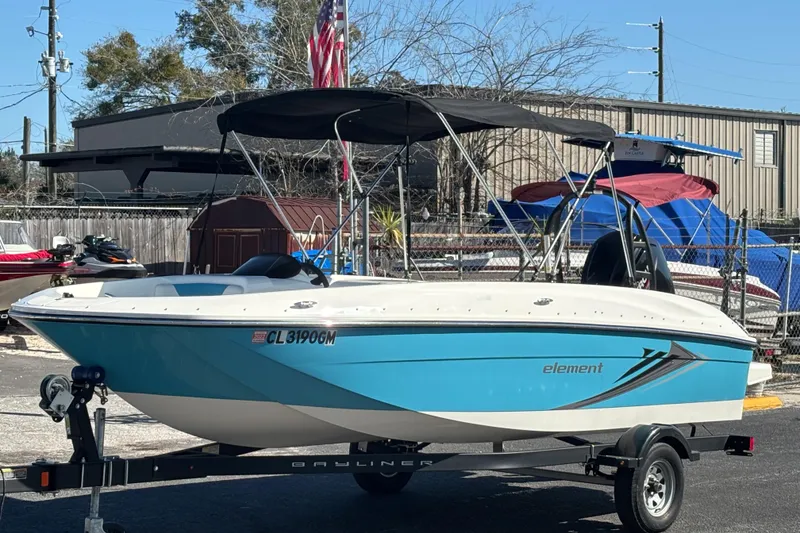 Slide: The Image of 2021 Bayliner Element E18 boat on trailer, blue and white design, parked outdoors. - 8