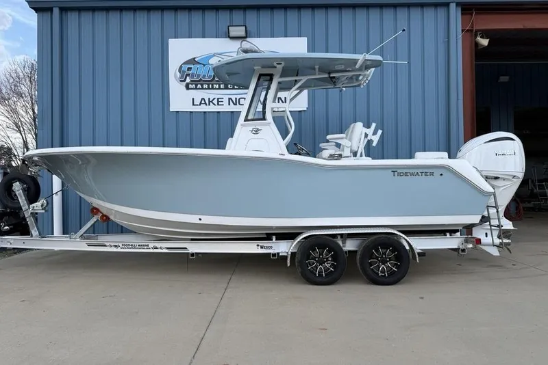 Slide: The Image of 2026 Tidewater 232 LXF boat on trailer, parked outside a marine dealership. - 2