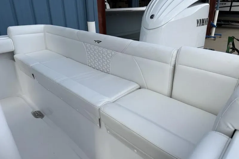Slide: The Image of 2026 Tidewater 232 LXF boat interior with white cushioned seating and Yamaha engine. - 21