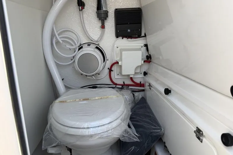 Slide: The Image of 2026 Tidewater 232 LXF boat interior with marine toilet and plumbing components. - 32