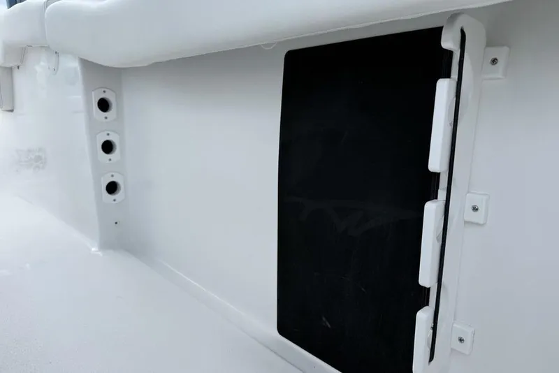 Slide: The Image of 2026 Tidewater 232 LXF boat interior detail with storage compartment and rod holders. - 33