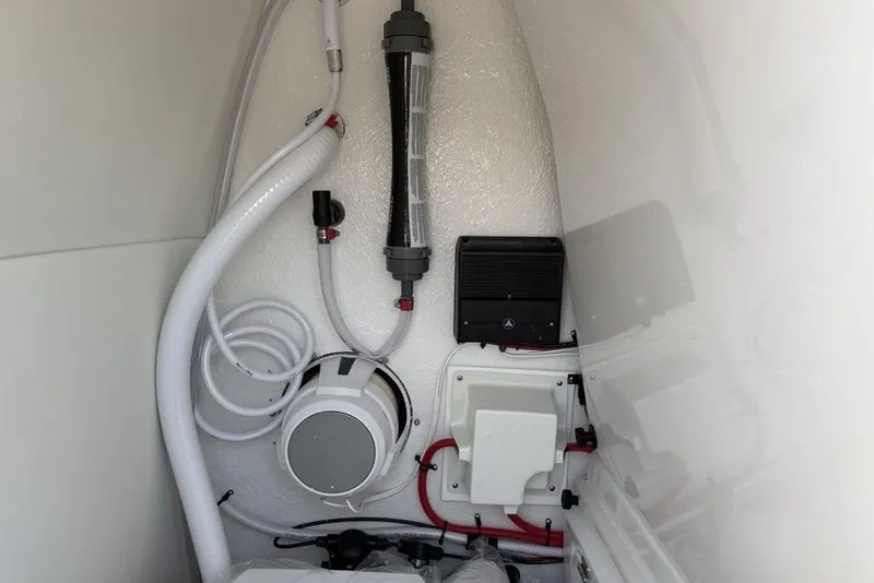 Slide: The Image of Interior view of 2026 Tidewater 232 LXF boat's technical compartment with hoses and equipment. - 34