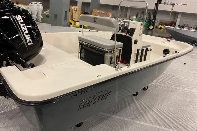 Slide: The Image of 2026 Carolina Skiff EV180 Sea Skiff with Suzuki engine in showroom setting. - 3