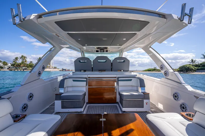 Slide: The Image of 2019 Tiara Sport 38 LS luxury yacht interior with seating, ocean view, and clear skies. - 11