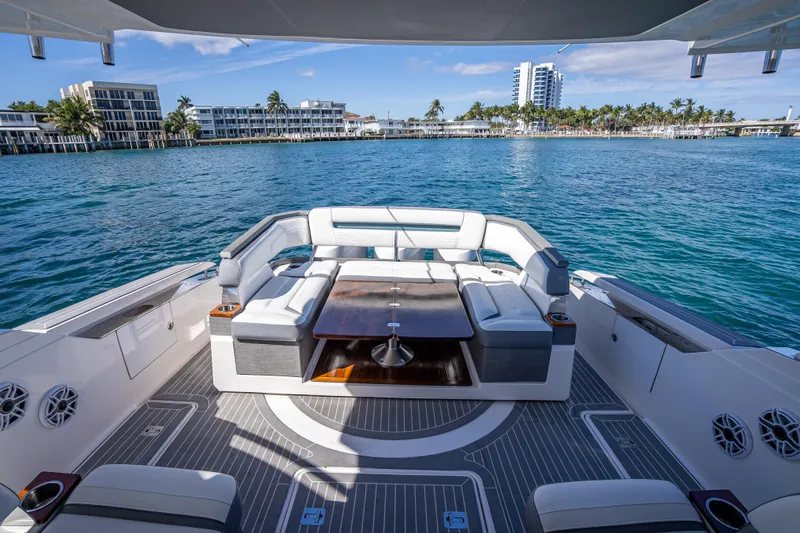 Slide: The Image of 2019 Tiara Sport 38 LS yacht with luxurious seating, docked near waterfront buildings. - 13