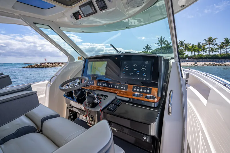 Slide: The Image of 2019 Tiara Sport 38 LS boat cockpit with advanced navigation system, steering wheel, and ocean view. - 15