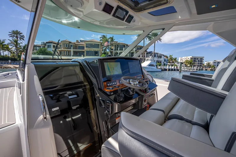 Slide: The Image of 2019 Tiara Sport 38 LS yacht cockpit with modern controls and waterfront view. - 17