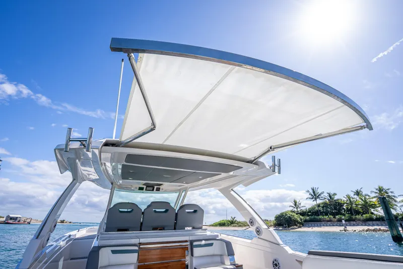 Slide: The Image of 2019 Tiara Sport 38 LS boat with sunshade, ocean view, and clear blue sky. - 30